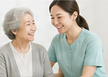 어르신과 요양보호사가 나란히 앉아 웃으며 대화하는 모습