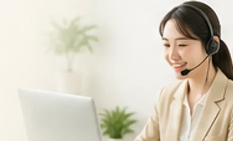 헤드셋을 쓴 상담사가 웃으며 전화 상담을 하는 모습