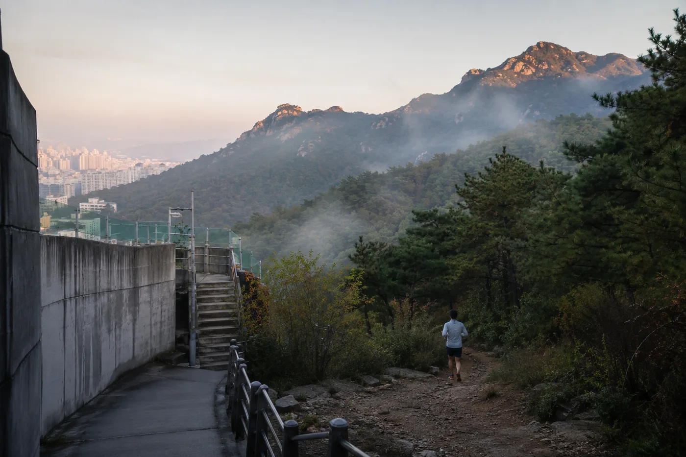 A runner leaving the concrete underpass for a mountain trail
