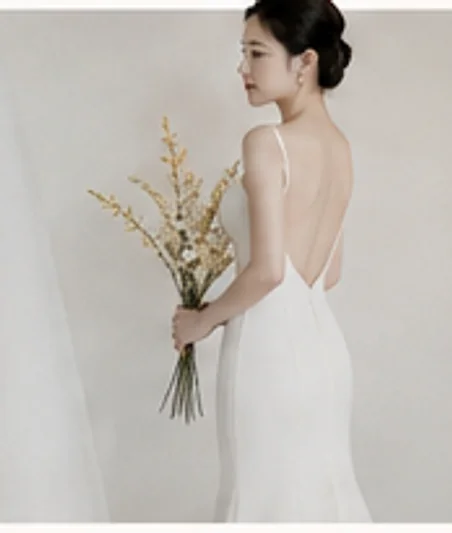 마른 꽃다발을 들고 흰 커튼 앞에 선 신부의 뒷모습