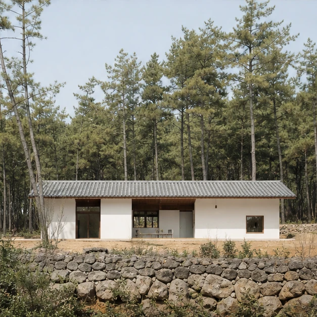 소나무 숲 앞에 길게 놓인 흰색 주택
